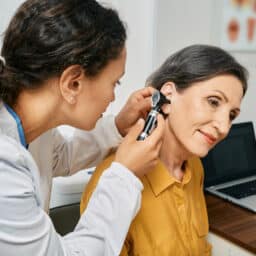 Doctor examines woman's ear