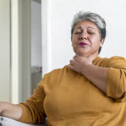 Woman holding her throat