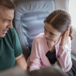 Father and daughter having ear pain during a plane flight