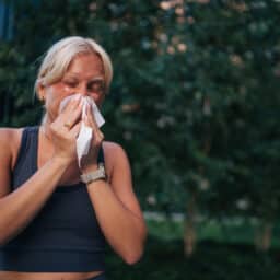 Young sporty woman blowing nose after training outdoors