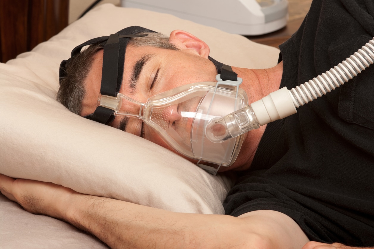 Man with sleeping apnea and CPAP machine.