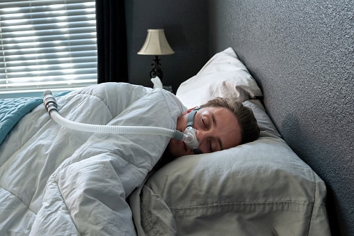 Man sleeping with a CPAP machine.