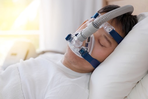 Man sleeping with a CPAP machine.