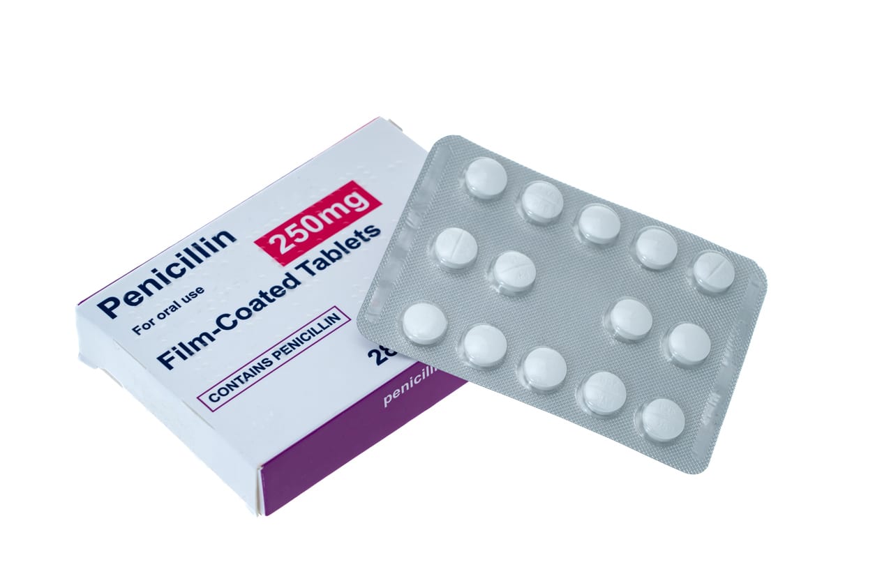 Penicillin box and pills - white background.